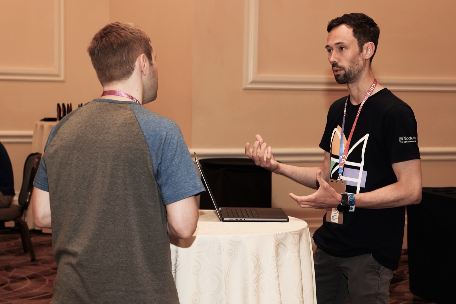 Two attendees in conversation at a standing table